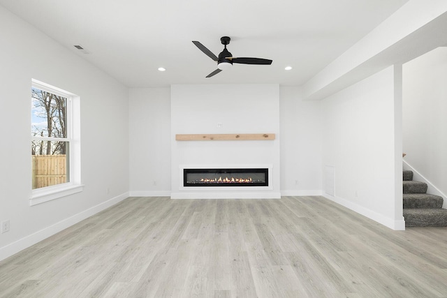 unfurnished living room featuring light wood-type flooring and ceiling fan