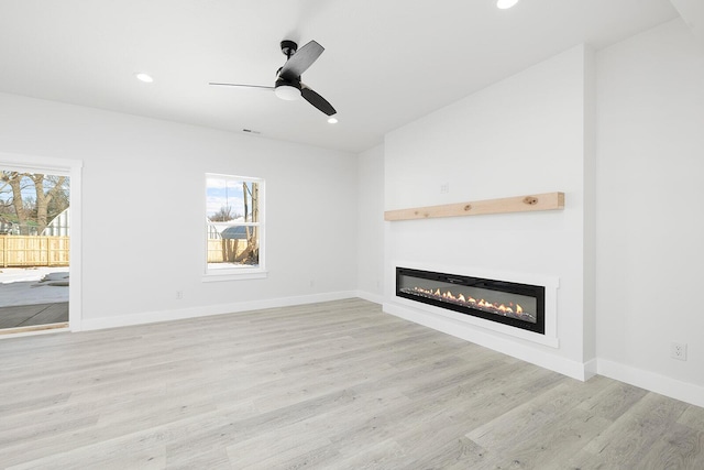 unfurnished living room featuring ceiling fan and light hardwood / wood-style floors