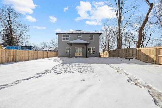 view of snow covered rear of property