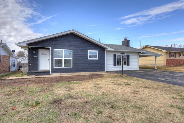 ranch-style house with a carport and a front lawn