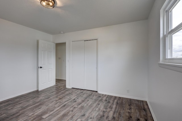 unfurnished bedroom featuring a closet and hardwood / wood-style flooring