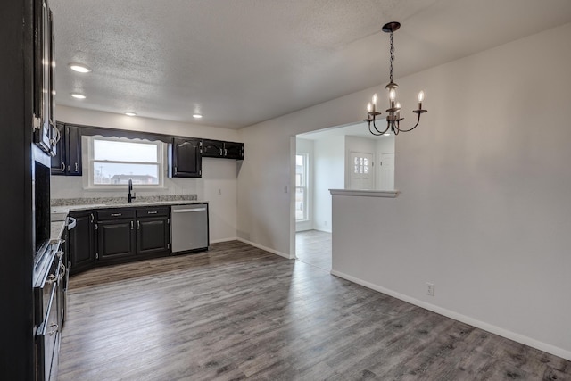 kitchen featuring a notable chandelier, stainless steel dishwasher, plenty of natural light, and hardwood / wood-style flooring