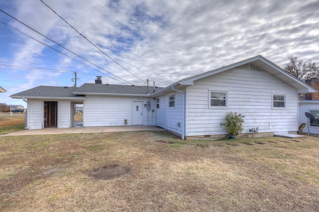 back of house featuring a lawn and a patio