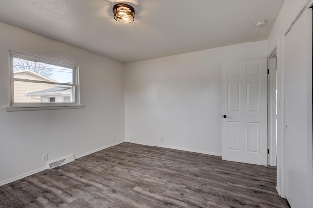 empty room featuring dark wood-type flooring