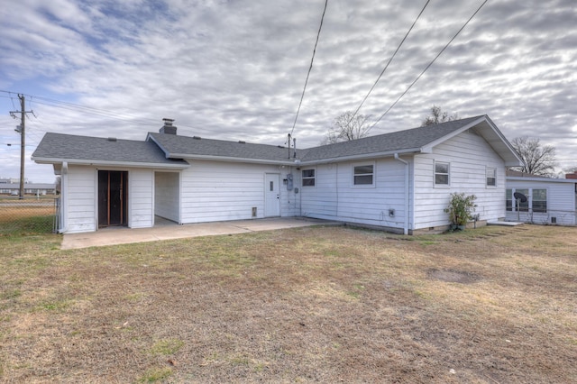 rear view of property featuring a patio area and a lawn