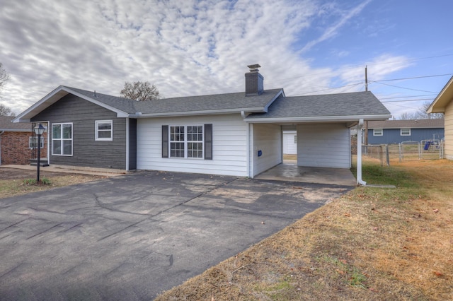 rear view of property featuring a yard and a carport