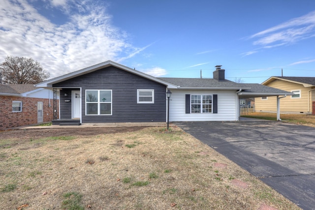 ranch-style home with a carport and a front lawn