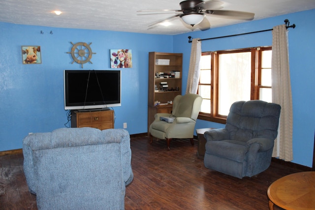 living room featuring ceiling fan, a textured ceiling, and dark hardwood / wood-style floors