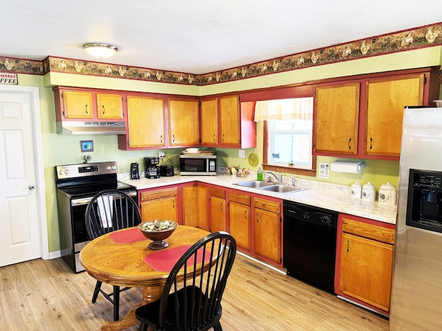 kitchen with sink, stainless steel appliances, and light hardwood / wood-style flooring