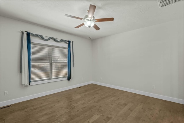 spare room with hardwood / wood-style floors and ceiling fan