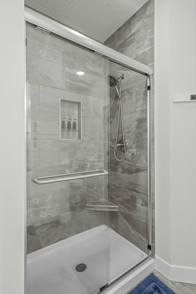 bathroom featuring a shower with door