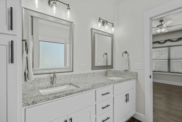 bathroom with plenty of natural light, hardwood / wood-style flooring, ceiling fan, and vanity