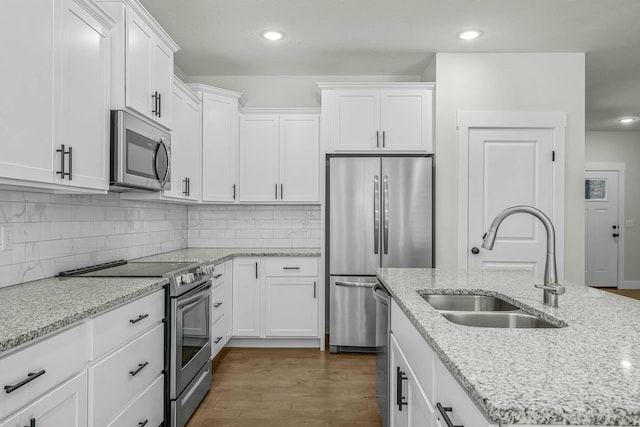 kitchen with sink, stainless steel appliances, white cabinetry, and dark hardwood / wood-style flooring