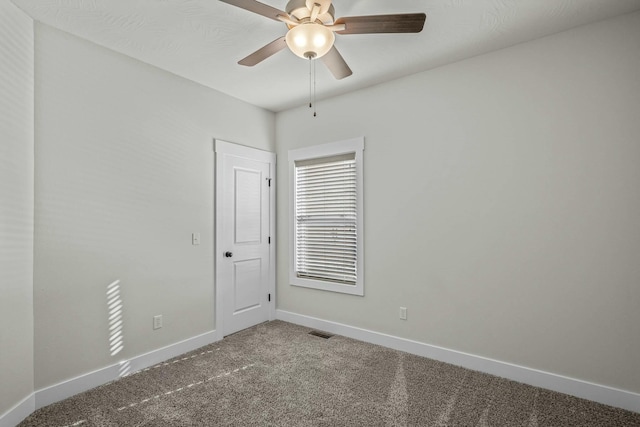 carpeted spare room featuring ceiling fan