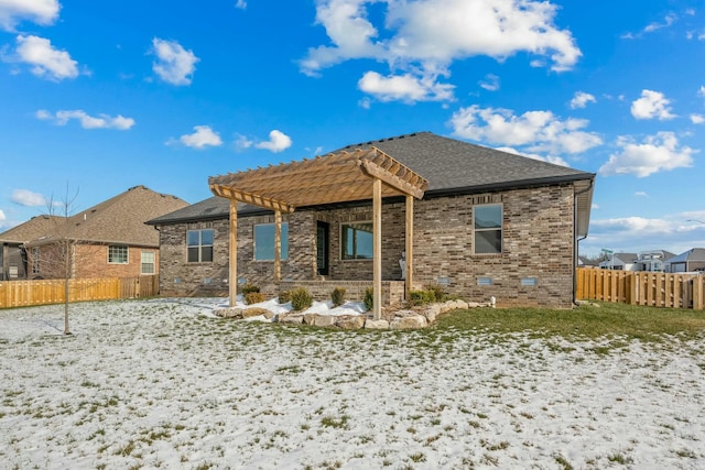 snow covered back of property featuring a pergola