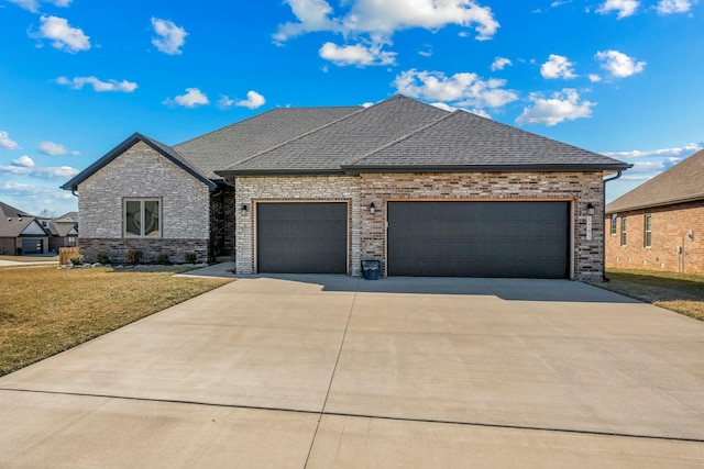 view of front facade featuring roof with shingles, an attached garage, driveway, and a front lawn