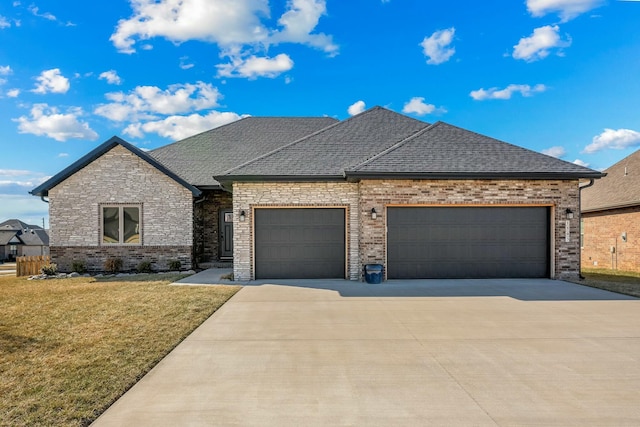 view of front of home featuring a garage, concrete driveway, roof with shingles, and a front lawn