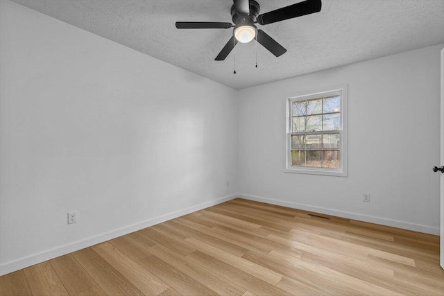 empty room with light wood-type flooring, ceiling fan, and a textured ceiling