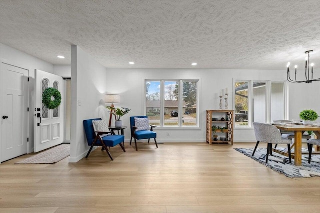 foyer entrance featuring light hardwood / wood-style flooring, a chandelier, and plenty of natural light