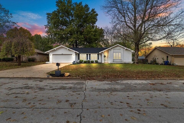 ranch-style home featuring a yard and a garage