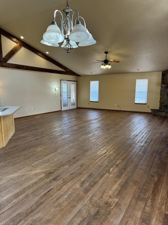 unfurnished living room featuring ceiling fan with notable chandelier, dark hardwood / wood-style flooring, sink, and a wealth of natural light