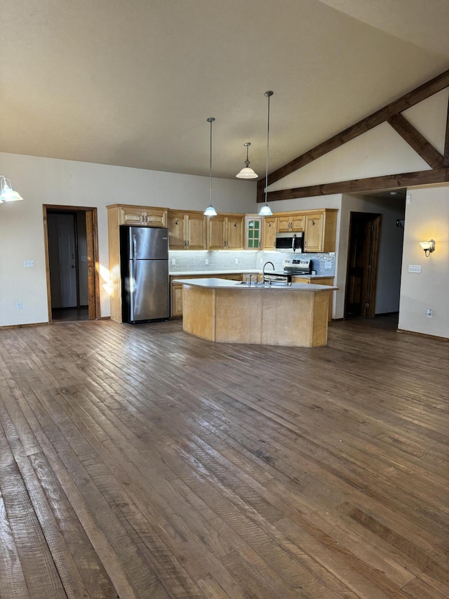 kitchen with appliances with stainless steel finishes, an island with sink, decorative backsplash, hanging light fixtures, and dark wood-type flooring