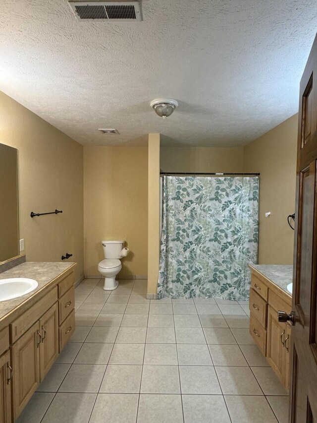 bathroom featuring toilet, vanity, and tile patterned flooring