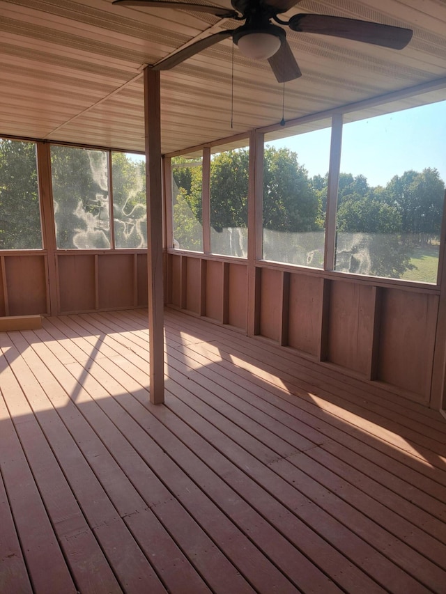 unfurnished sunroom featuring ceiling fan, a water view, and plenty of natural light