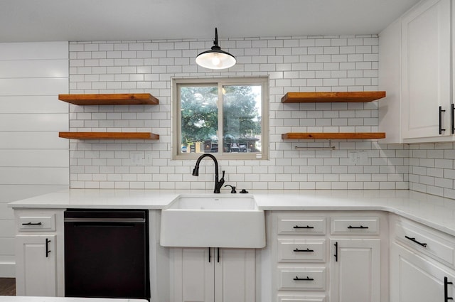 kitchen featuring sink, black dishwasher, white cabinetry, and decorative backsplash