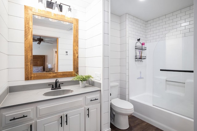 full bathroom featuring hardwood / wood-style floors, vanity, ceiling fan, toilet, and tub / shower combination