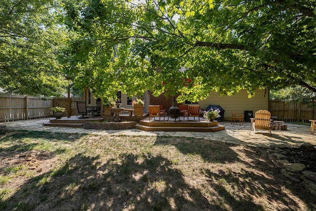 view of yard with a wooden deck, a patio area, and a fire pit