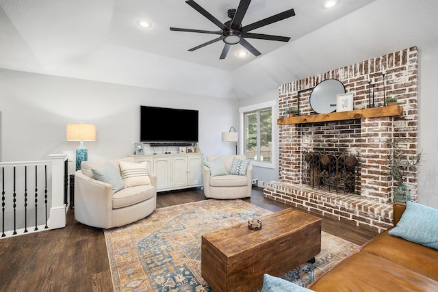 living room featuring ceiling fan, a brick fireplace, dark hardwood / wood-style flooring, and a tray ceiling