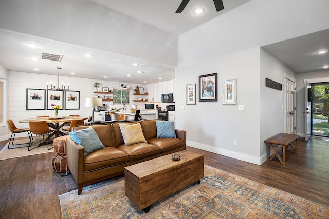 living room featuring ceiling fan with notable chandelier and wood-type flooring