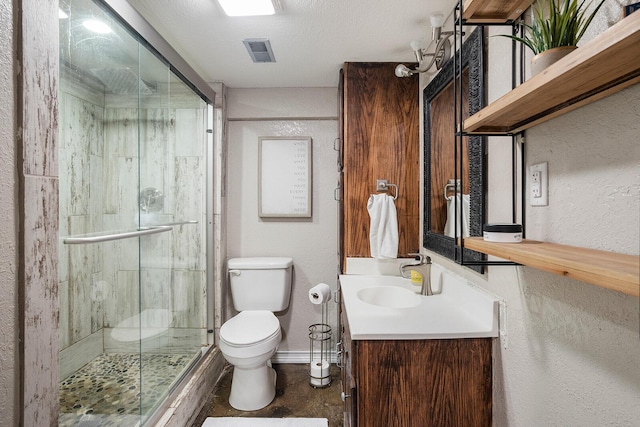 bathroom with vanity, a shower with shower door, a textured ceiling, and toilet