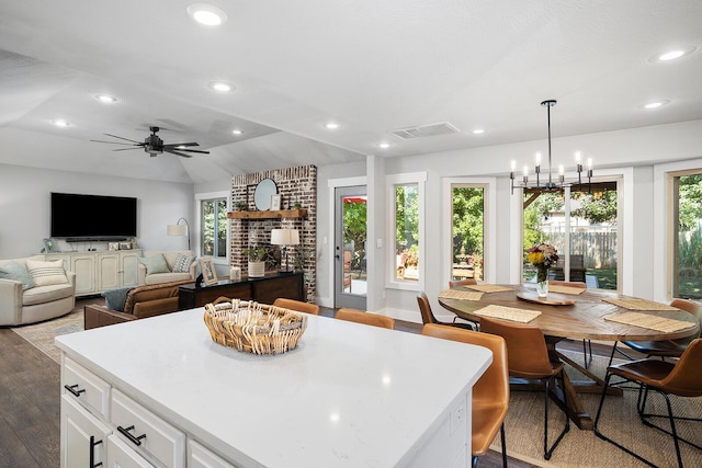 kitchen featuring a healthy amount of sunlight, hardwood / wood-style floors, white cabinets, and decorative light fixtures