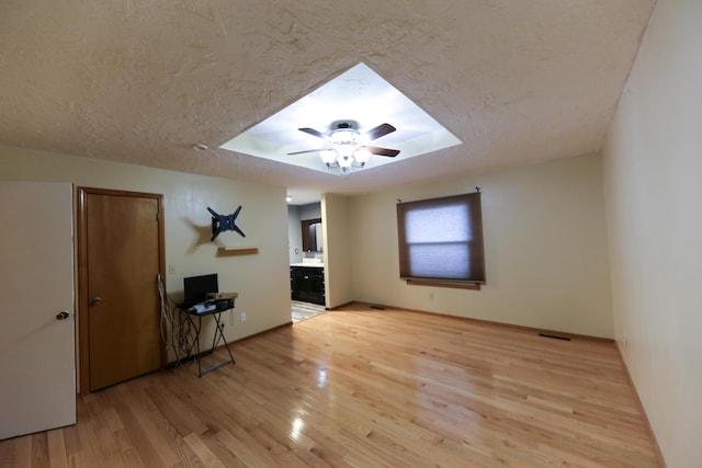 interior space featuring a textured ceiling, light wood-type flooring, and ceiling fan