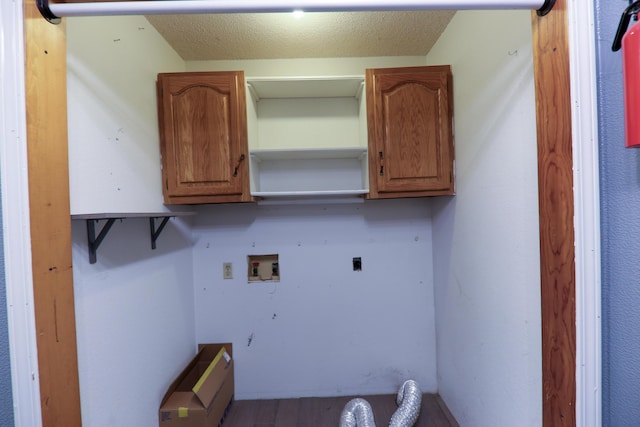 clothes washing area featuring cabinets, hookup for a washing machine, and hookup for an electric dryer