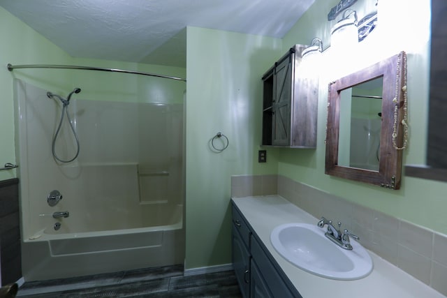 bathroom featuring bathing tub / shower combination, tasteful backsplash, a textured ceiling, and vanity