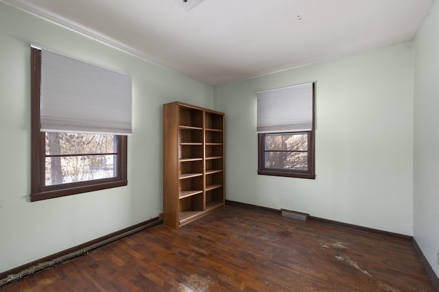 unfurnished room with a healthy amount of sunlight and dark hardwood / wood-style floors