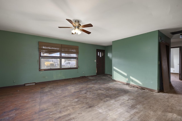 empty room with ceiling fan and dark hardwood / wood-style flooring