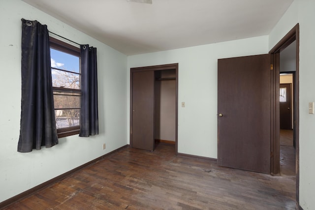 unfurnished bedroom featuring dark wood-type flooring and a closet