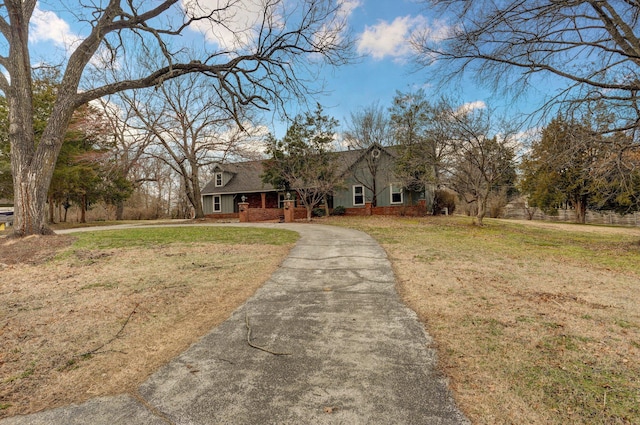 view of front facade featuring aphalt driveway, a front lawn, and roof with shingles