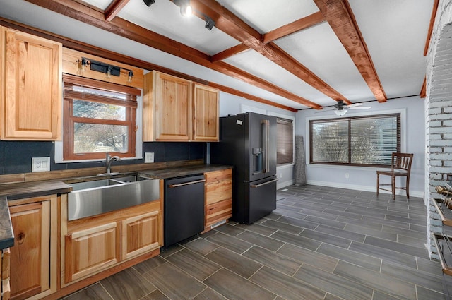 kitchen with dark countertops, black fridge with ice dispenser, dishwasher, and a sink