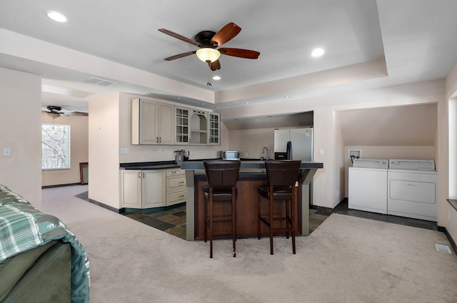 kitchen with visible vents, separate washer and dryer, dark countertops, and dark carpet