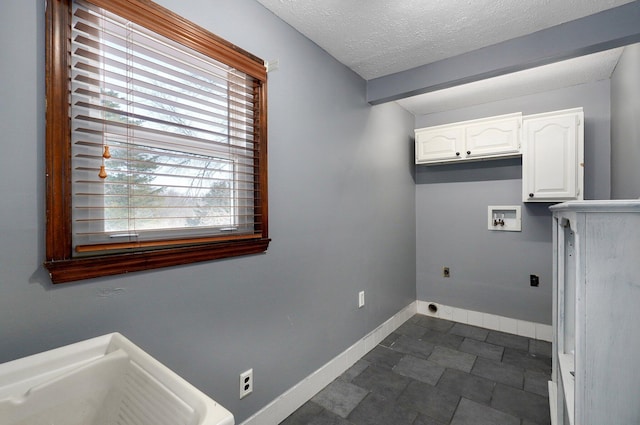 washroom featuring electric dryer hookup, a textured ceiling, cabinet space, baseboards, and hookup for a washing machine