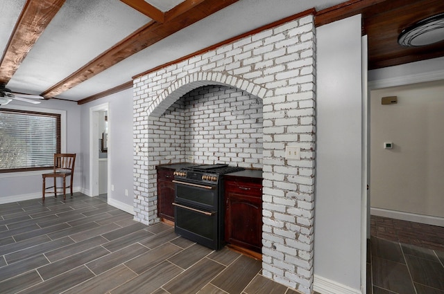 interior space with a ceiling fan, visible vents, baseboards, wood finish floors, and beamed ceiling