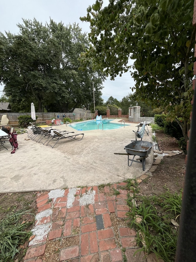 view of pool with a patio area, a fenced in pool, and fence