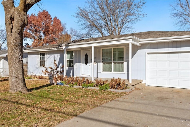 ranch-style home featuring covered porch, a front lawn, and a garage