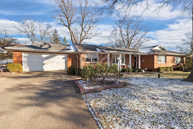 single story home featuring driveway, an attached garage, and brick siding