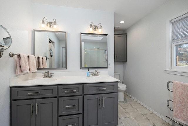 full bathroom with toilet, double vanity, and a sink